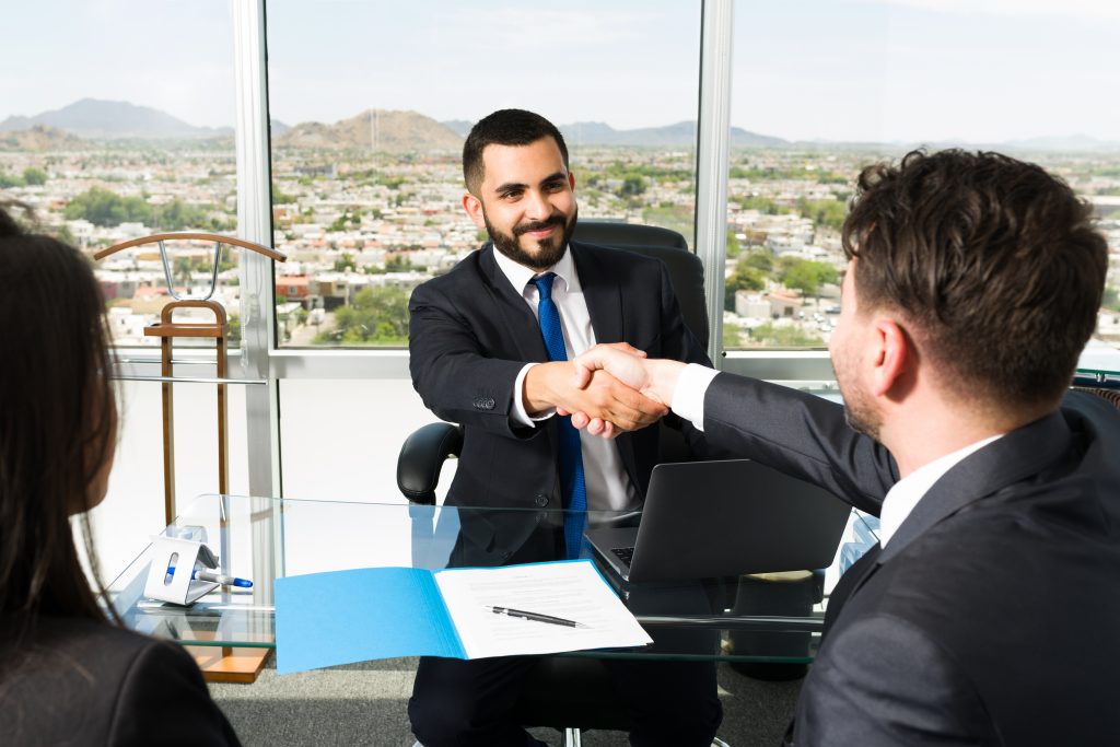 Professional solicitor shaking hands with a client after finalising a successful property transaction